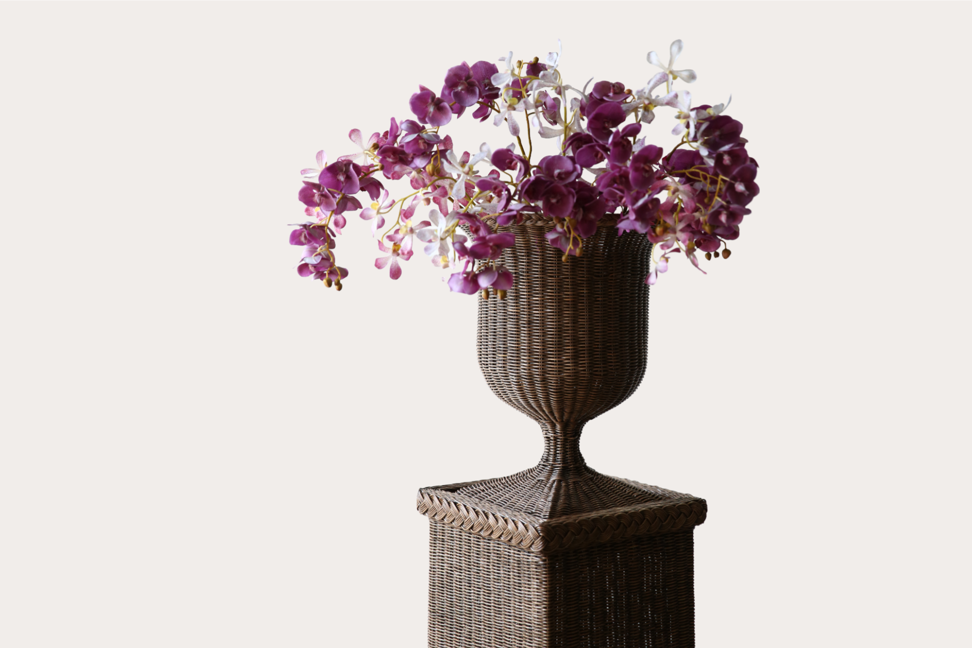 Handwoven natural rattan pedestal and vase set, ideal for indoor or covered outdoor display.