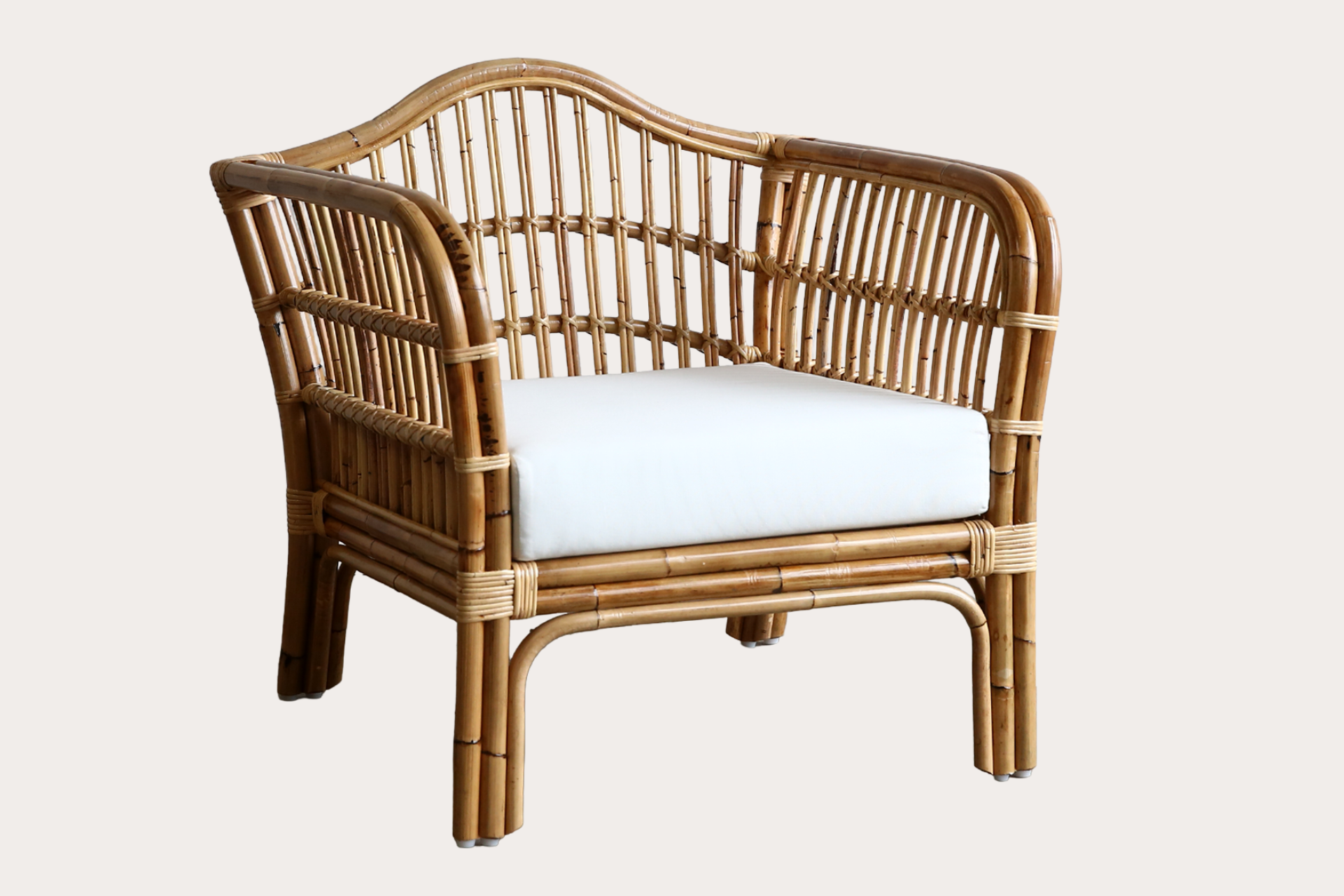 Wicker chair with white cushion on a light beige background
