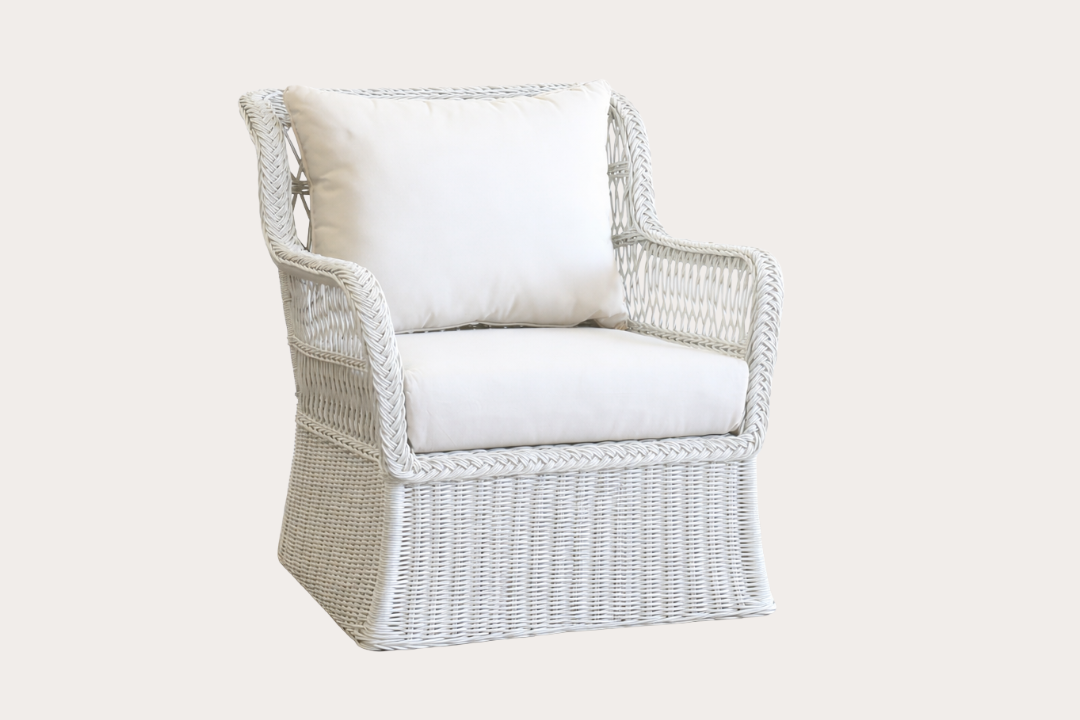 Wicker chair with white cushions on a light beige background