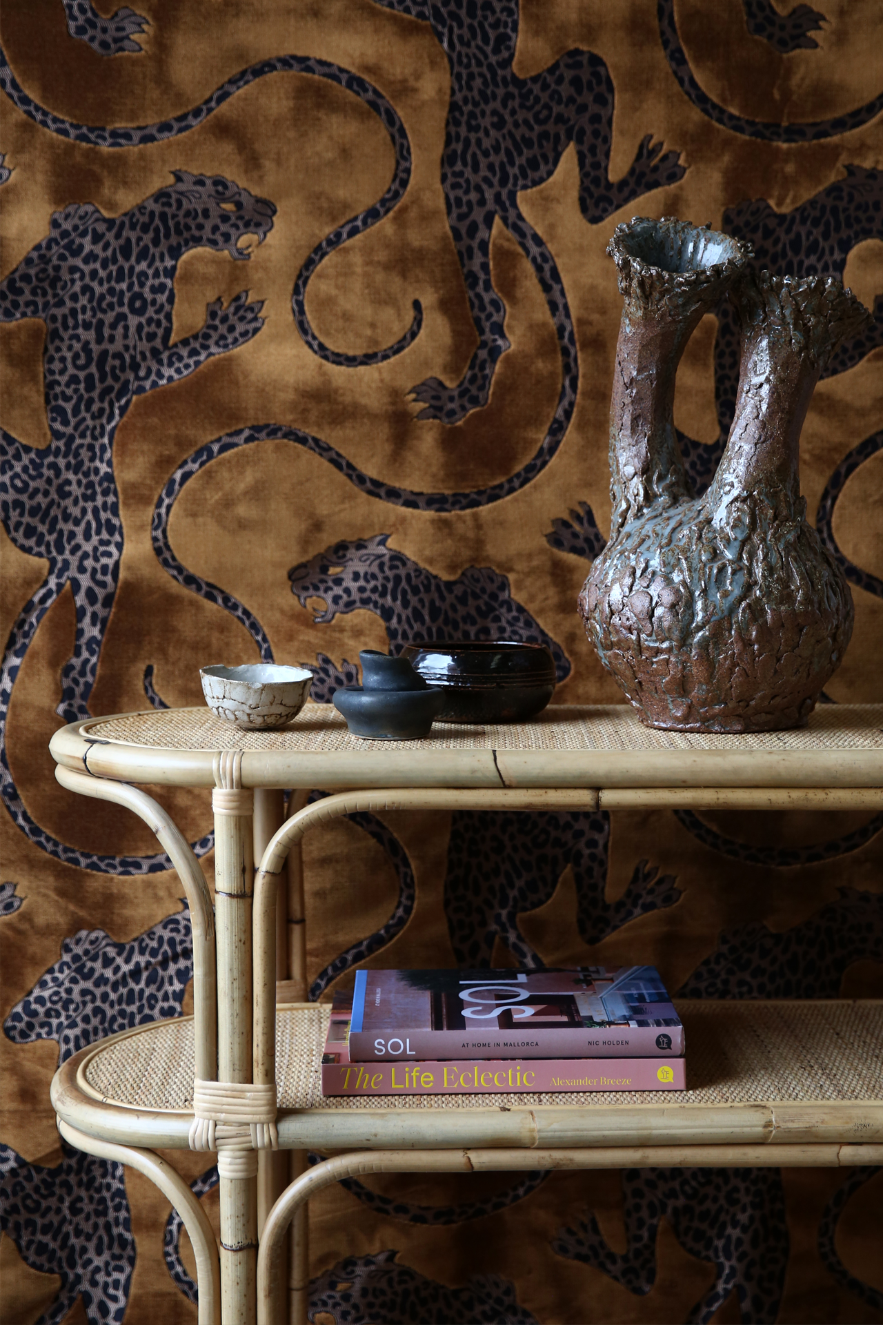 Natural rattan curved console table with Catherine Martin Fabric as backdrop. Custom made.