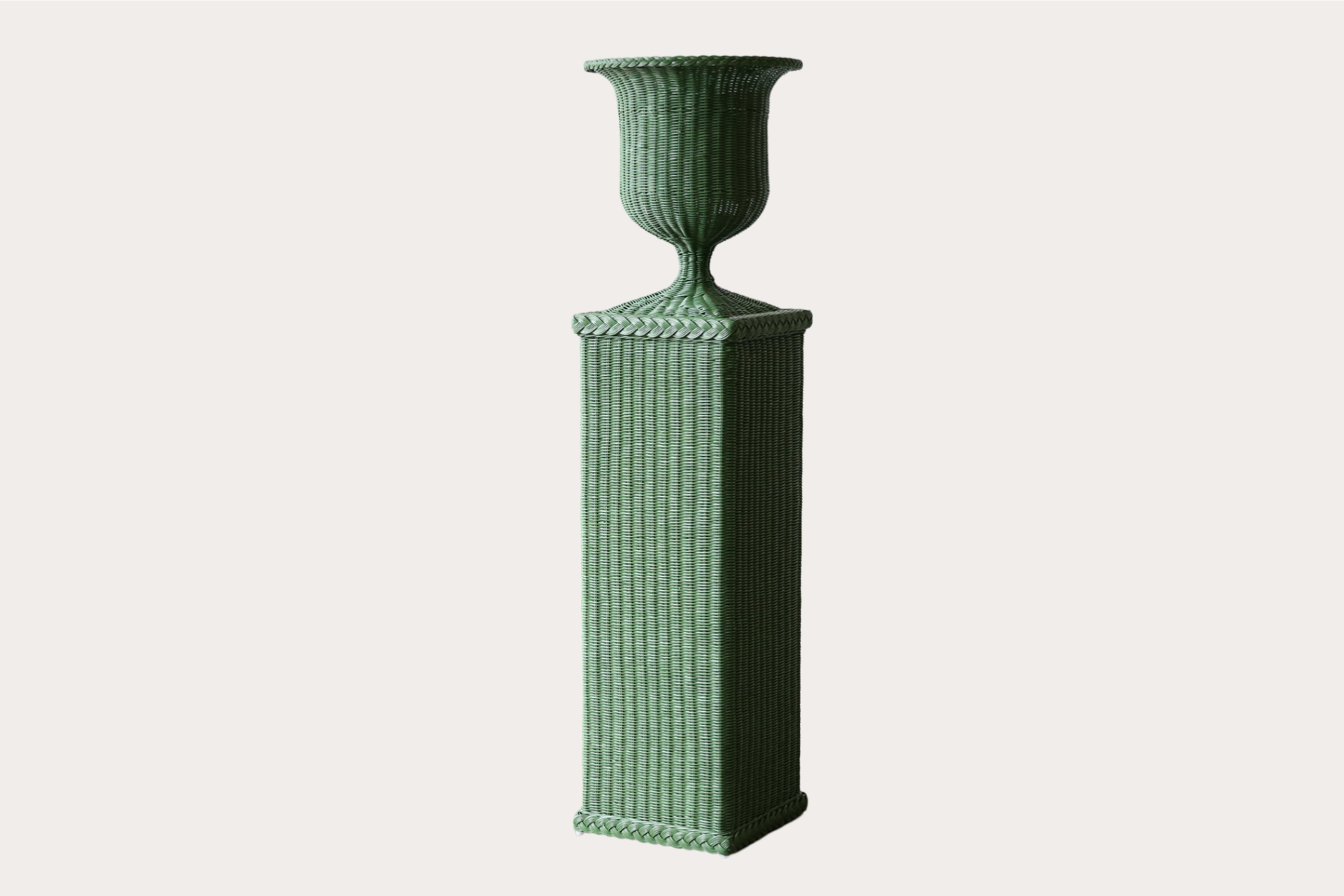 Tall green wicker pedestal vase with fluted body and natural foliage display