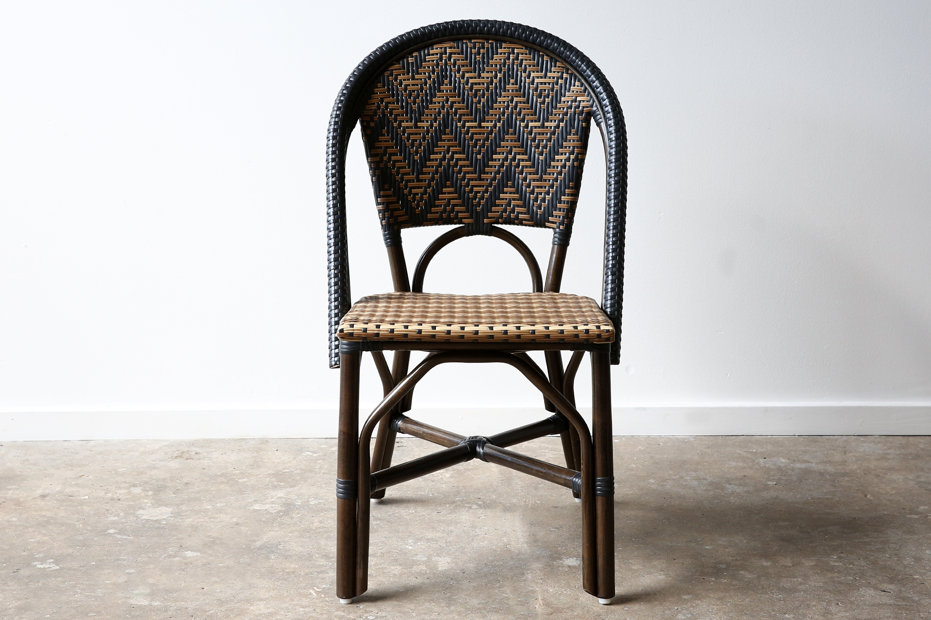 Commercial-grade woven side chair with black and natural chevron pattern, suitable for indoor and outdoor dining