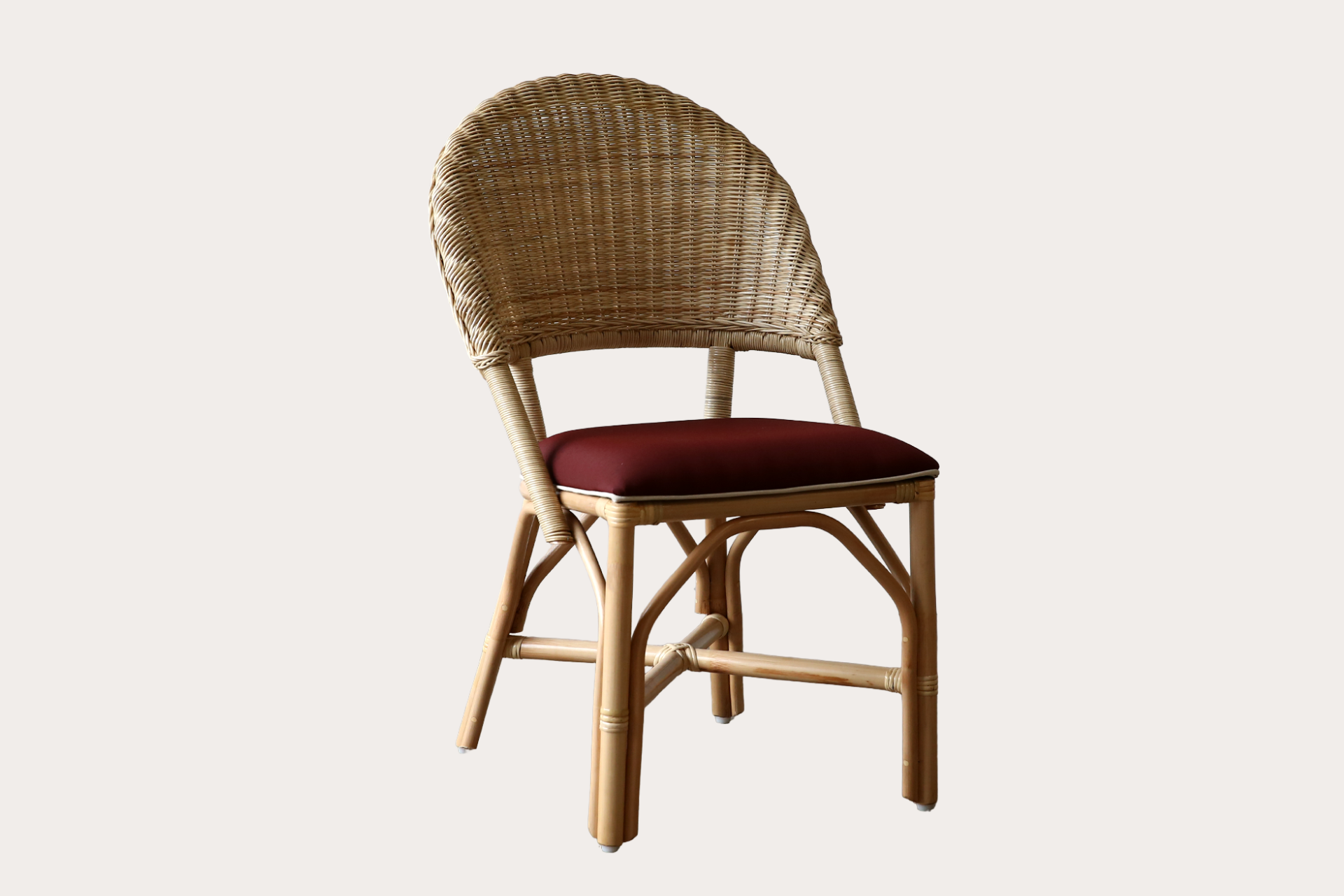 Drucker style Wicker chair with a red cushion on a white background
