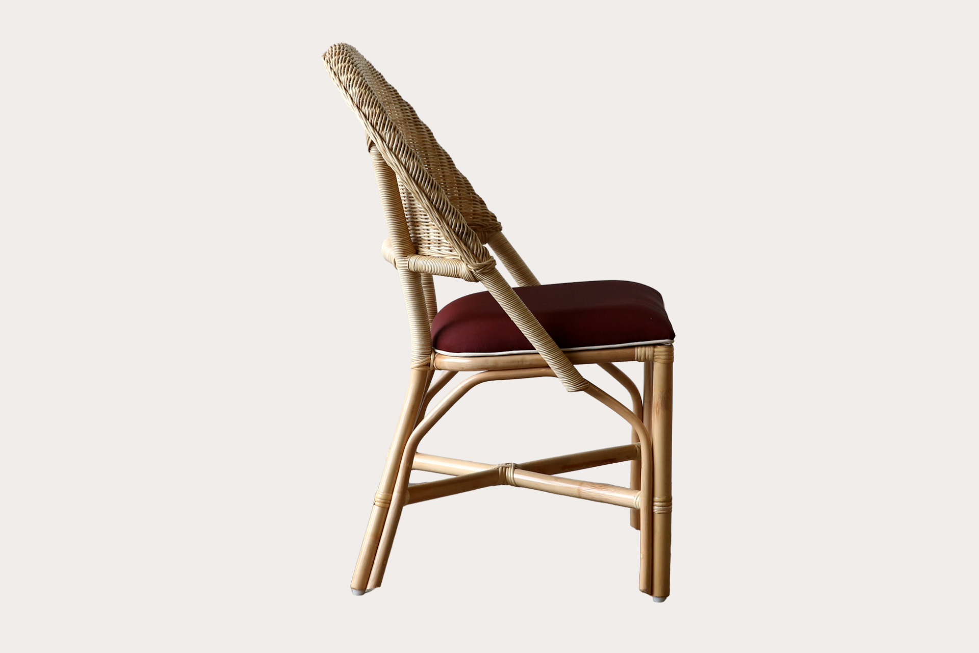Drucker style Wicker chair with a red cushion on a white background