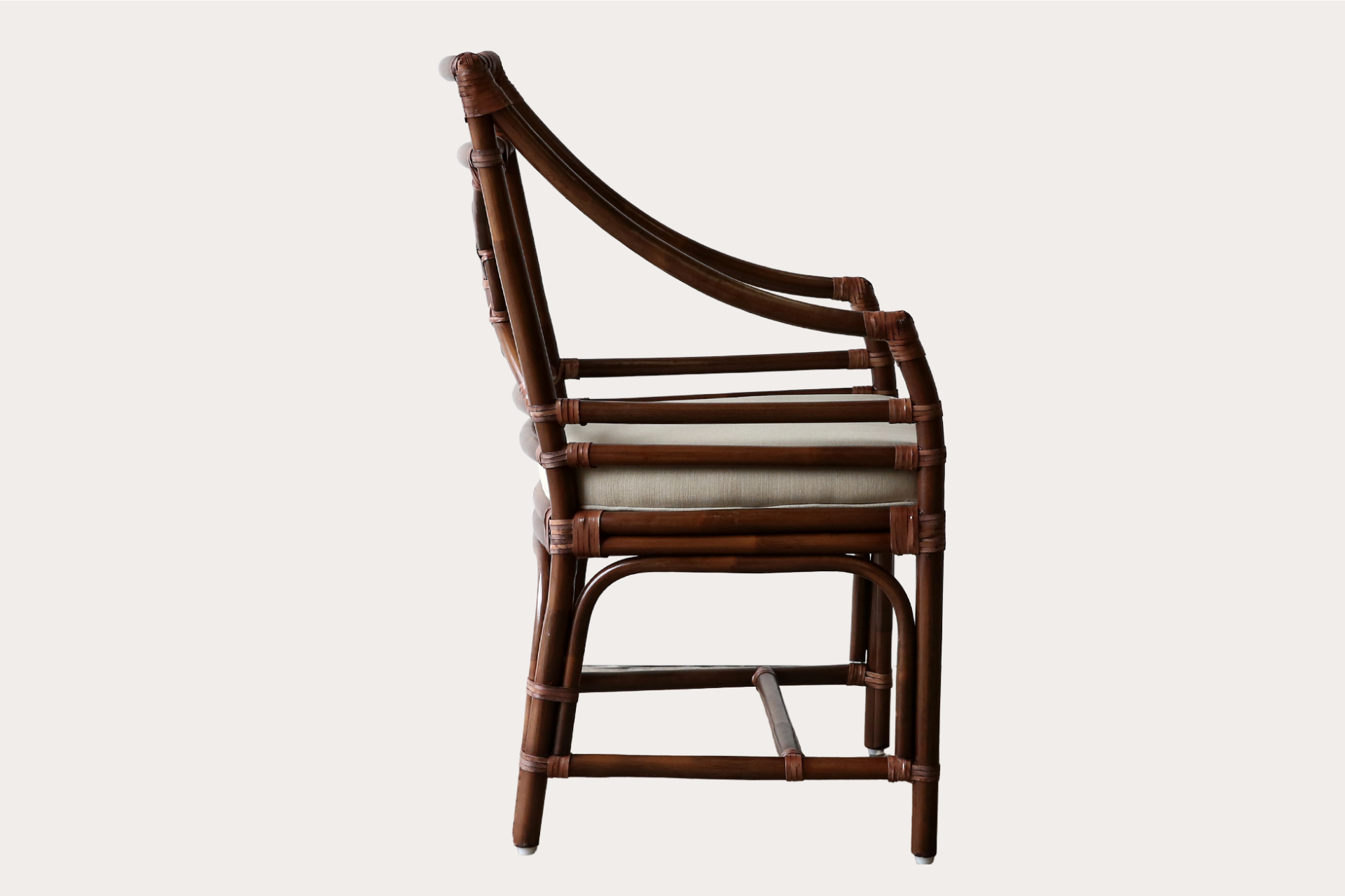 Handcrafted rattan dining chair in brown wash finish with circular lattice back and padded seat