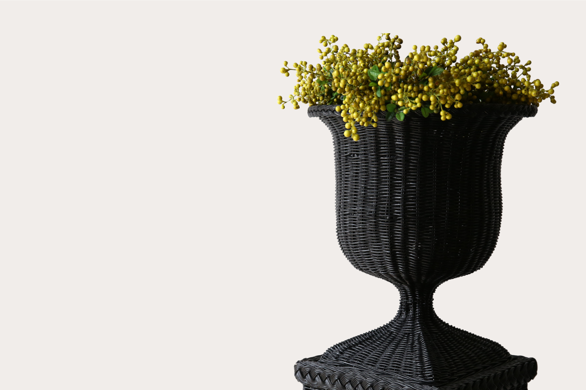 Handwoven natural rattan pedestal and vase set, ideal for indoor or covered outdoor display.
